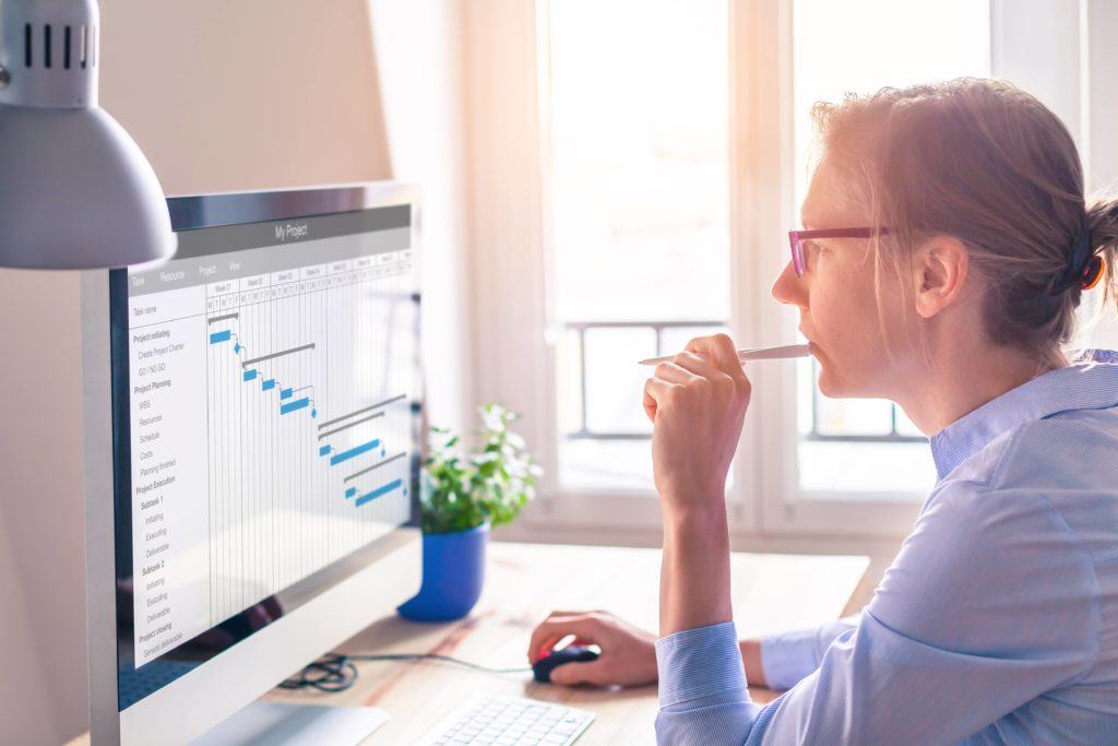 Female project manager looking at schedule on computer